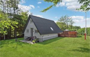 uma casa branca com um telhado preto num quintal em 2 Bedroom Amazing Home In Thyholm em Thyholm