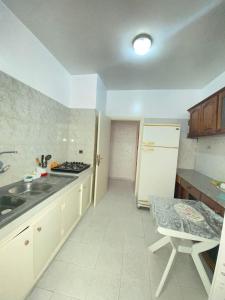 cocina con fregadero y nevera blanca en Centre ville appartement en Alhucemas