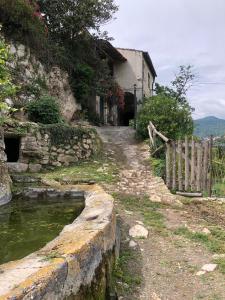 a stone path next to a building with a fence at Cà di Pippo "Riccio" appartamento Loc Boragni Orco Feglino in Vezzi Portio