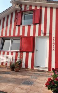 una casa rossa e bianca con finestre rosse e una porta di Casiña Palmira a Finisterre
