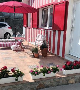 a patio with potted plants and an umbrella at Casiña Palmira in Finisterre