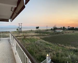 a porch with a view of a field and the ocean at Tsapoga in Pálioura
