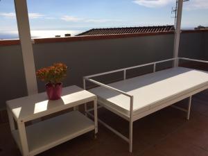 Un balcón con una cama y una mesa con una planta en Casa Martina en Aci Castello