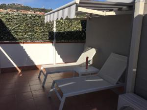 einen Balkon mit einem Stuhl, einem Regenschirm und einer Bank in der Unterkunft Casa Martina in Aci Castello