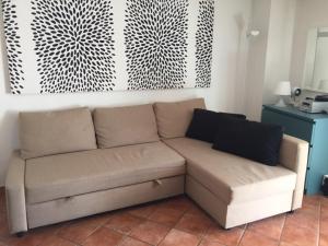 ein braunes Sofa in einem Wohnzimmer mit einer Wand in der Unterkunft Casa Martina in Aci Castello