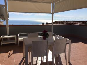 einen Tisch und Stühle auf einer Terrasse mit Sonnenschirm in der Unterkunft Casa Martina in Aci Castello