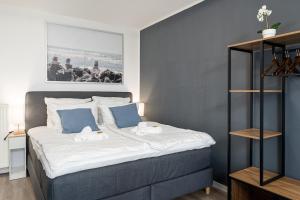 ein Schlafzimmer mit einem großen Bett mit blauen Wänden in der Unterkunft Federnest - Luxus-Studio - Kingsize Boxspringbett - Home-Office mit Monitor und Drucker - 11 Min Hbf in Duisburg