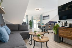 uma sala de estar com um sofá e mesas em Federnest - Luxus-Studio - Kingsize Boxspringbett - Home-Office mit Monitor und Drucker - 11 Min Hbf em Duisburg