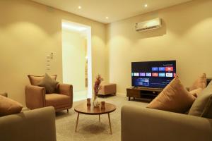 een woonkamer met banken en een flatscreen-tv bij نزل ليلى الفندقية الفاخرة luxury in Abha