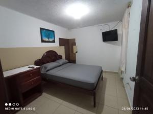 a small bedroom with a bed and a dresser at Hostal SAMARY in Atacames