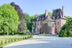 ein altes Schloss mit einer Straße davor in der Unterkunft Le Petit Château de Barbizon au Bois du Mée in Barbizon