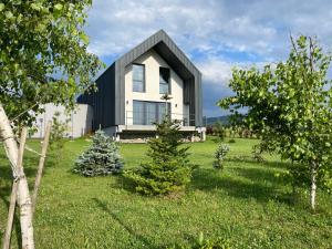 una casa en blanco y negro en una colina con árboles en Stodoła 55, en Milówka