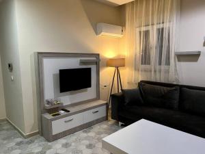 sala de estar con sofá negro y TV de pantalla plana en Basement floor, Erasta Mall karşısı, 1+0 stüdyo '23', en Antalya