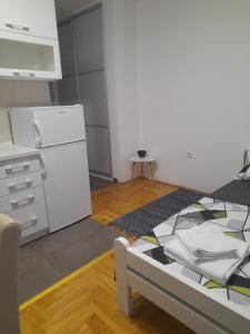 a kitchen with a bed and a white refrigerator at Nikola NS in Novi Sad