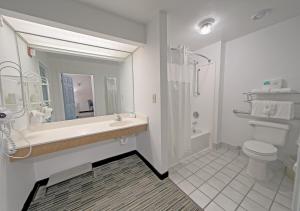 uma casa de banho branca com um lavatório e um WC em All Season Suites em Pigeon Forge