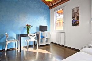 フィレンツェにあるApartments Florence San Galloのテーブル、椅子2脚、テレビが備わる客室です。