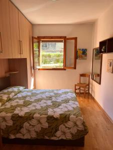 a bedroom with a bed and a window at La Casina di Checco in Marciana Marina