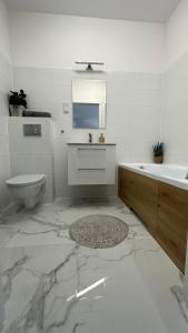 a white bathroom with a sink and a toilet at Letnica41 by MYPART in your apartment in Gdańsk
