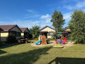 un patio con un parque infantil con un juego de juegos en Jantar Rodzinne Domki, en Bobolin