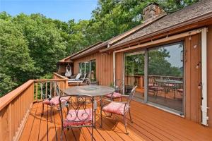 una terrazza in legno con tavolo e sedie. di White River Mountain Manor- Million dollar view a Eureka Springs