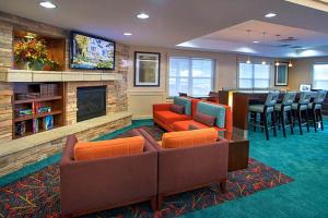 ein Wohnzimmer mit einem Sofa, Stühlen und einem Kamin in der Unterkunft Residence Inn by Marriott Saratoga Springs in Saratoga Springs