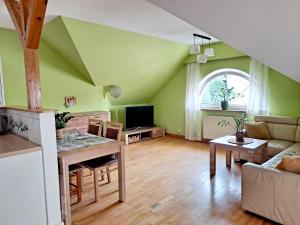 a living room with green walls and a table at Apartament Centrum - Giżycko in Giżycko