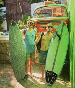 dos hombres parados junto a sus tablas de surf en frente de un autobús en ITH Amazing Hostel Sayulita en Sayulita