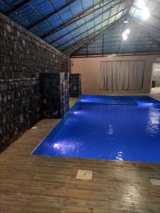 a large blue swimming pool in a building at Sunrise Chalet شالية الشروق الجبل الاخضر in Duwaykhīlah