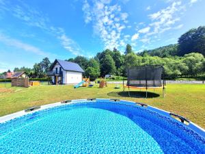 a swimming pool in a yard with a playground at Jelonkowo in Brenna