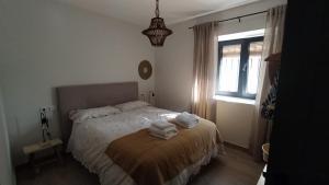een slaapkamer met een bed met handdoeken erop bij La Casa de Abajo in Arroyomolinos de la Vera