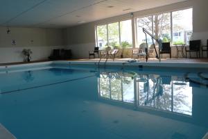 a large swimming pool with blue water in a building at Sunbird Cape Cod Resort in West Yarmouth