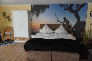 ein Schlafzimmer mit einem Bett mit einem Affen an der Wand in der Unterkunft Gästehaus Köhler in Waldsolms