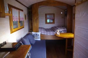 Zimmer mit einem Bett und einem Tisch in einem Zimmer in der Unterkunft Roulotte La Marmotte in Poinson-lès-Fays