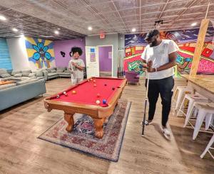 a man standing next to a pool table in a room at City House New Orleans Samesun in New Orleans