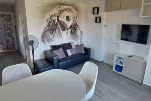 沃爾泰拉的住宿－Firenzuola Loft，客厅配有沙发和墙上的绘画