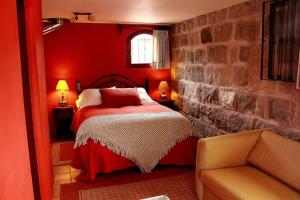 a red bedroom with a bed and a chair at Hacienda Hato Verde in Mulaló