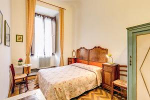 um quarto com uma cama grande e uma janela em Albergo San Giovanni em Florença