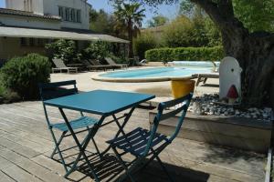 una mesa azul y dos sillas junto a una piscina en Studio avec piscine, en Corbère