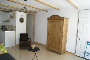 una sala de estar con una puerta de madera y una silla en Studio avec piscine, en Corbère