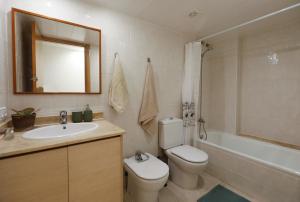 a bathroom with a toilet and a sink and a tub at Mazi Apartments Martinet in Mataró