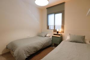 two beds in a room with a window at Mazi Apartments Martinet in Mataró