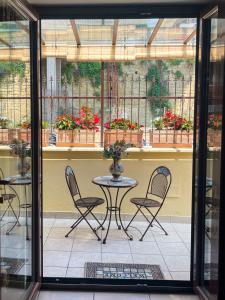 un patio con mesa, sillas y algunas plantas en Casa Nennella con Parcheggio Auto gratuito in Loco, en Nápoles