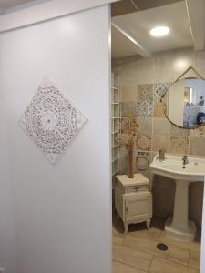 uma casa de banho com um lavatório e um espelho em Minha casa em Olhão