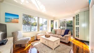 a living room with a couch and a tv at Beachside Beauty With Pool in Woorim