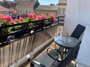 a balcony with a table and chairs and flowers at Sunny apartment in Vršac