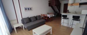 a living room with a couch and a table at Apartamentos El Jornu in Llanes