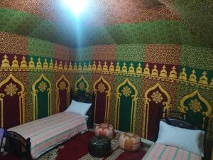 een kamer met 2 bedden en een kleurrijke muur bij Montazah yfrane taounate in Taounate