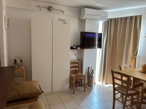 een woonkamer met een tafel en een tv aan de muur bij Es Pujols Vista Mare in Es Pujols