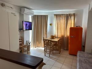 een keuken met een oranje koelkast en een tafel met stoelen bij Es Pujols Vista Mare in Es Pujols