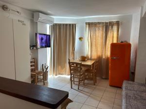 una cucina con frigorifero arancione e tavolo con sedie di Es Pujols Vista Mare a Es Pujols